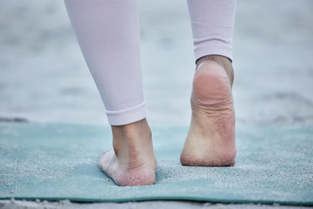 woman in yoga stretching feet at a beach training 2023 11 27 05 22 11 utc