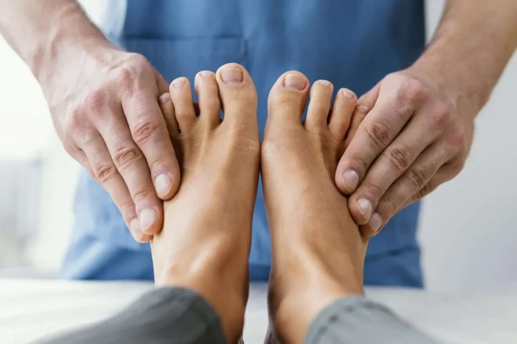 front view male osteopathic therapist checking female patient s toes 1320x880 1